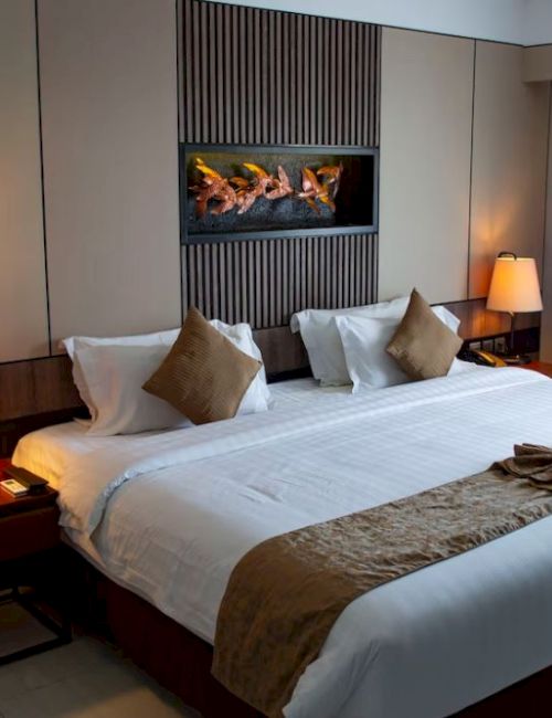 A neatly made hotel room with a large bed, two side tables with lamps, and a window with drapes letting in natural light, ending the sentence.
