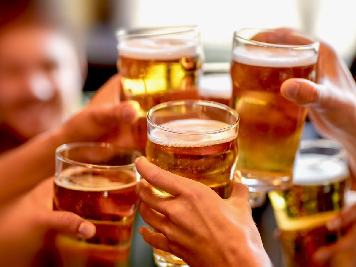 A group of people clinking glasses of beer in a cheers moment.